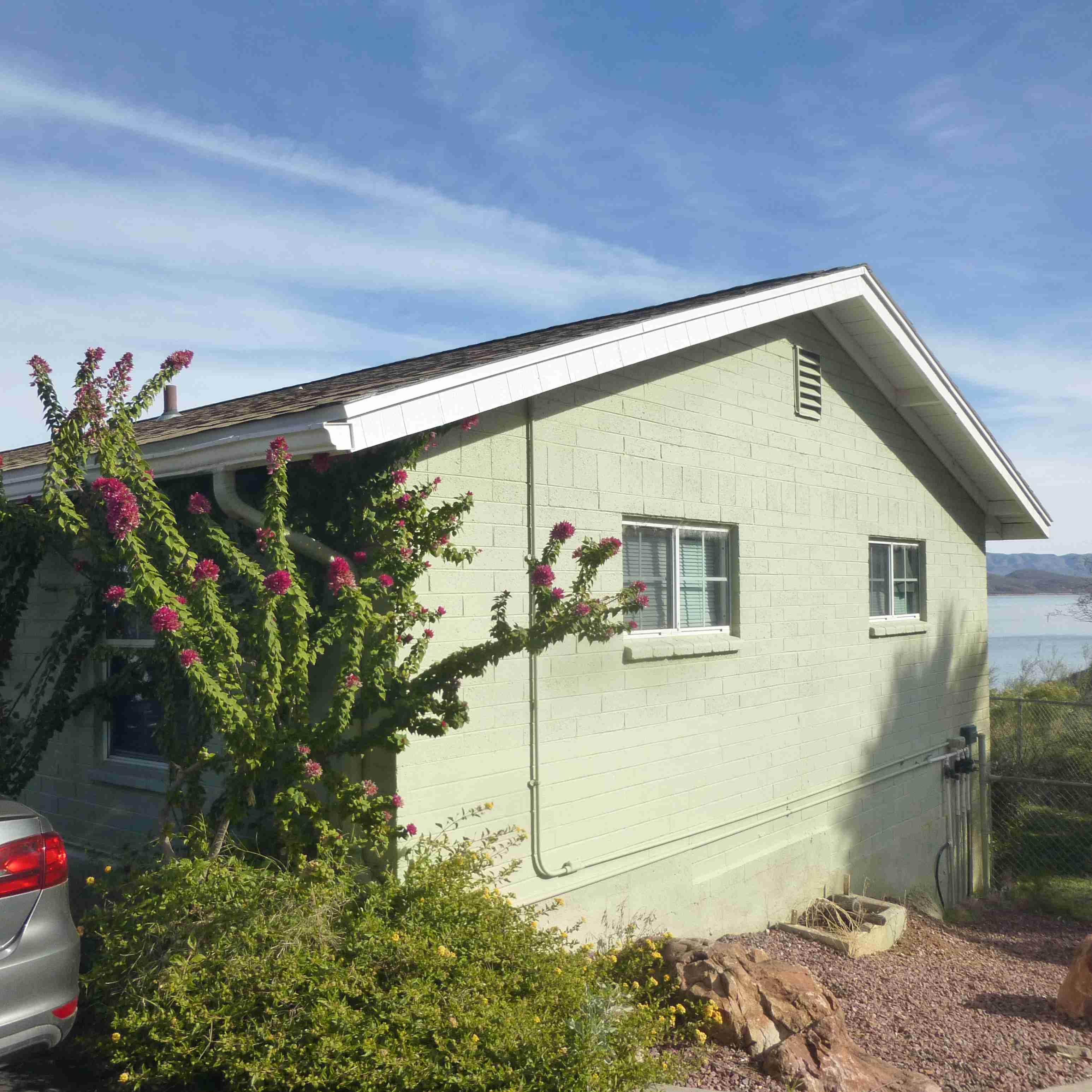 a picture of a house with a lake behind it.